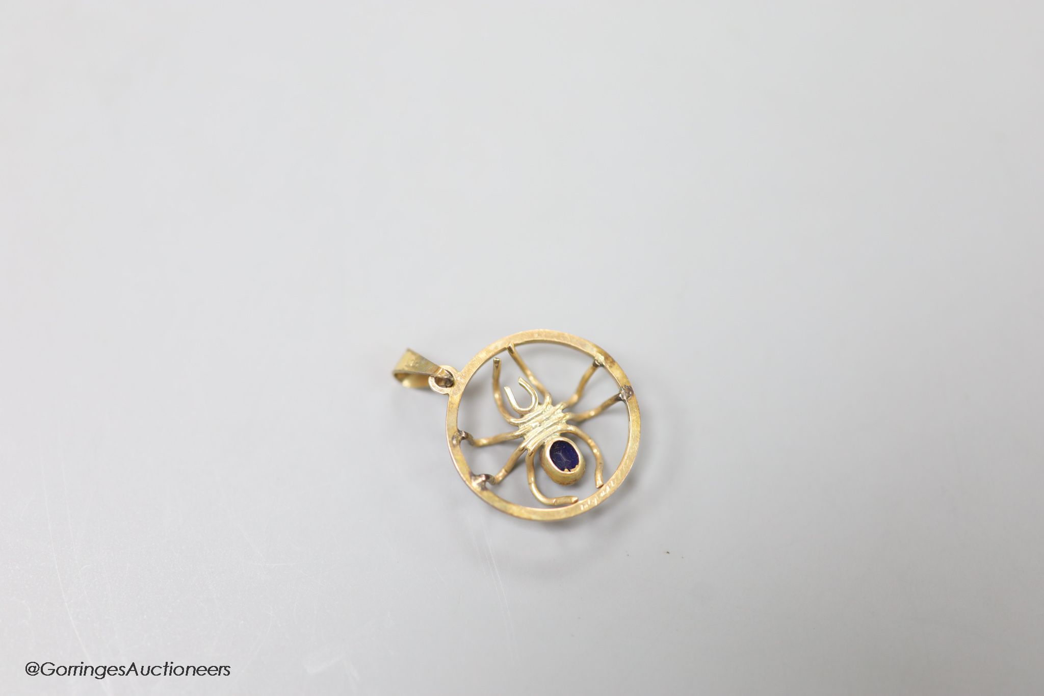 A 9ct, sapphire and ruby set circular spider pendant, 19mm, gross weight 1.9 grams.